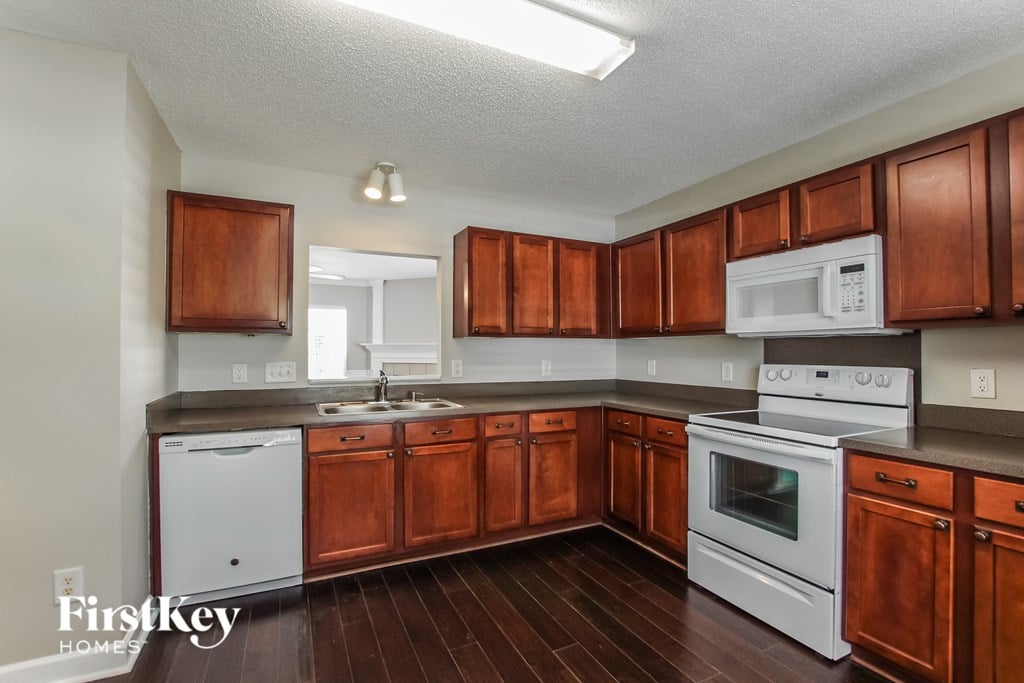 A kitchen with wooden cabinets and white appliances.