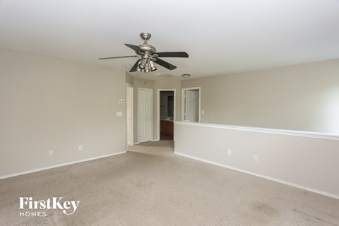 A spacious room with a ceiling fan and two doors.
