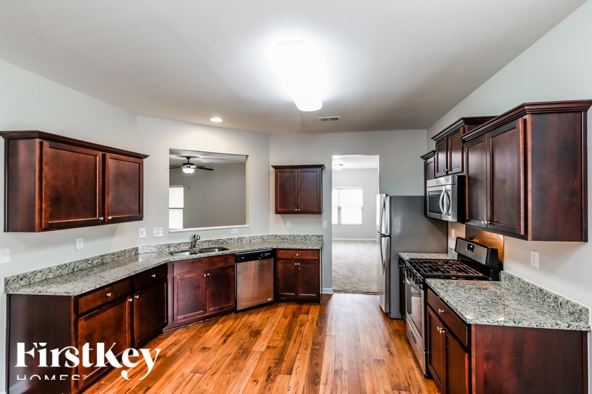 A kitchen with wooden cabinets and a granite countertop.