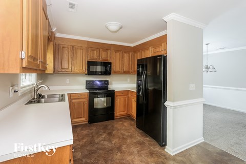 A kitchen with wooden cabinets and black appliances.