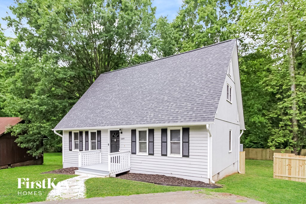 a small white house with a grey roof