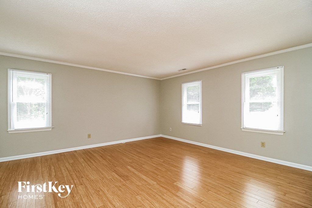 the living room of a house with wood floors and white walls