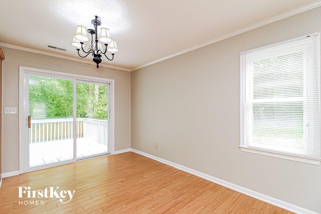 a living room with a wood floor and a door to a balcony