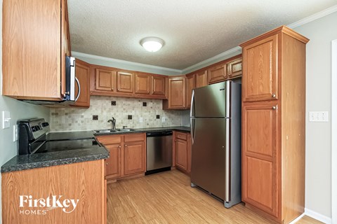 a kitchen with wooden cabinets and a stainless steel refrigerator