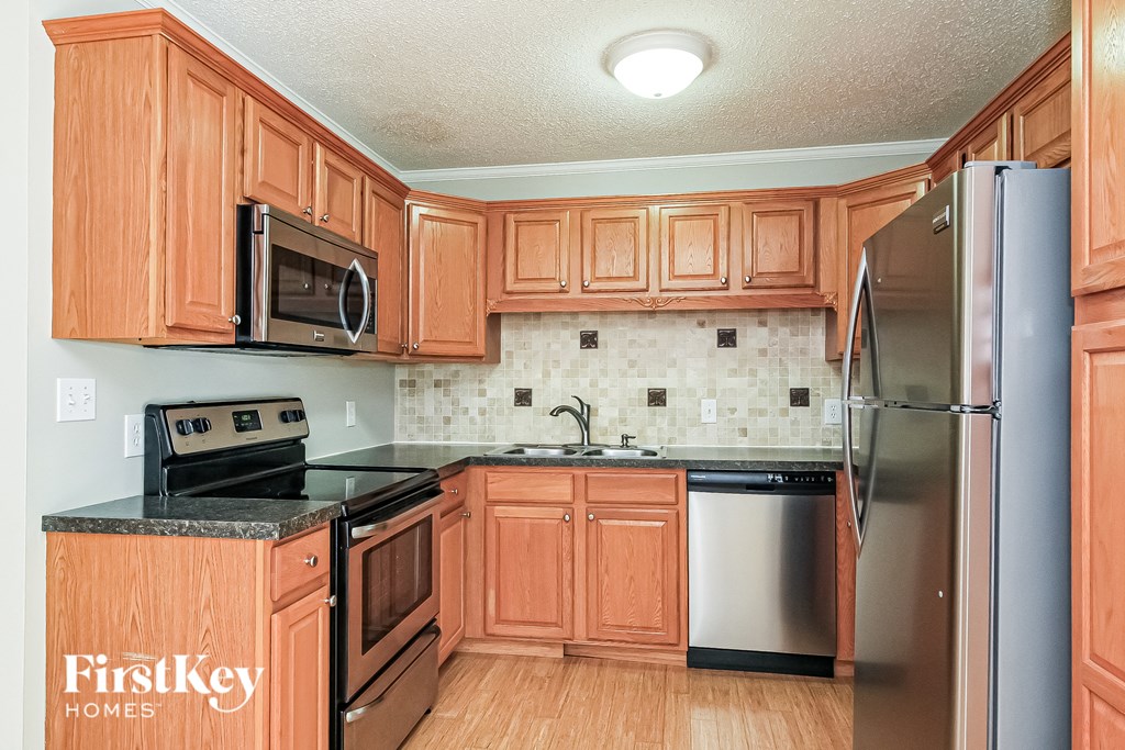 a kitchen with wooden cabinets and stainless steel appliances