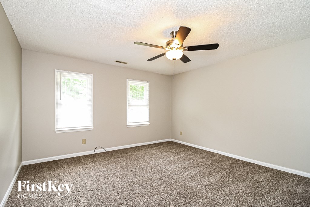 a bedroom with carpet and a ceiling fan