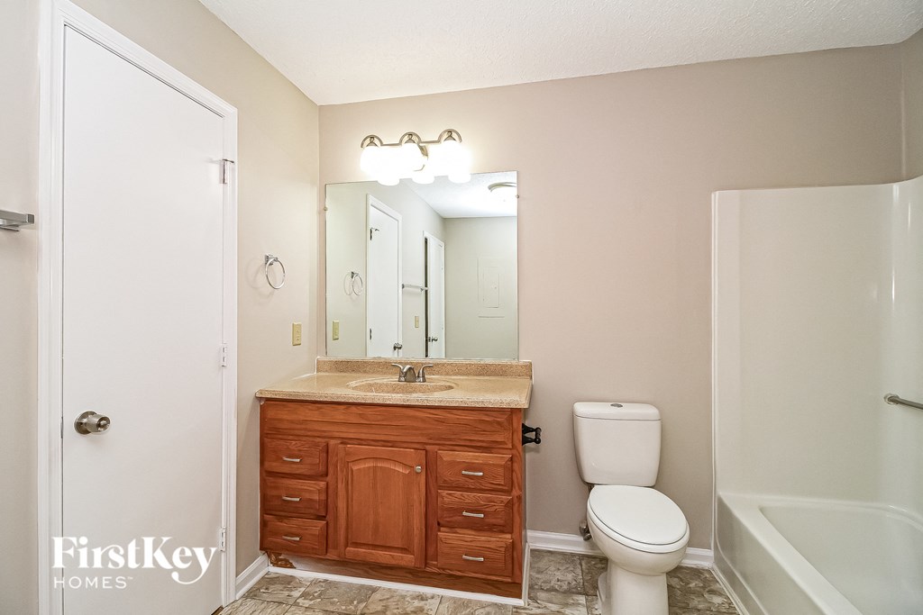 a bathroom with a toilet and a sink and a mirror