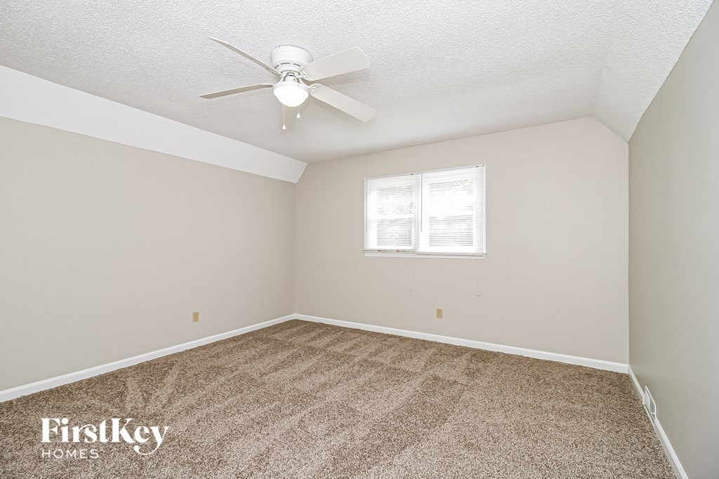 a bedroom with carpet and a ceiling fan