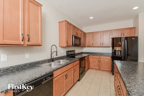 A kitchen with wooden cabinets and granite countertops.