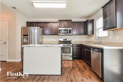 a kitchen with stainless steel appliances and dark wood cabinets