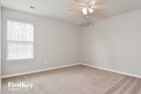 a bedroom with a carpeted floor and a ceiling fan
