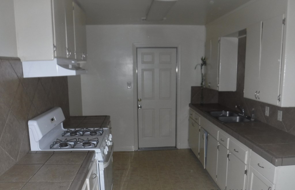 an empty kitchen with a stove and a sink