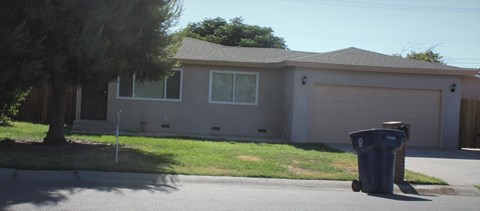 a house with a trash can in front of it