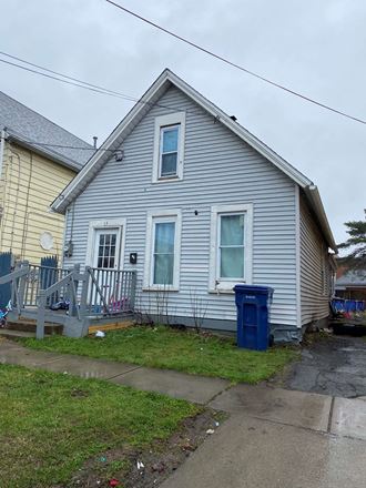a house with a blue trash can in front of it
