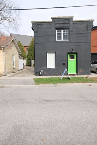 a black house with a green door on a street