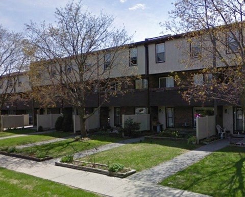 Apartment complex with a green lawn in front.