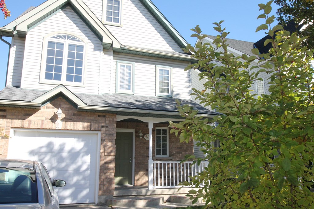 A house with a grey roof and a white garage door.