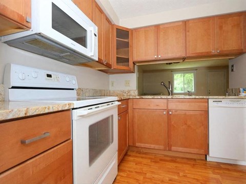 A kitchen with wooden cabinets and a white oven.