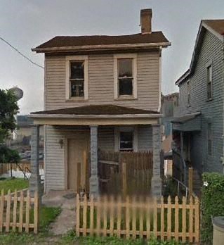 A house with a brown door and a brown fence.