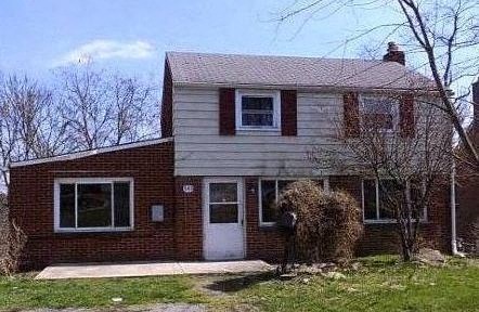 A two-story house with a white door and windows.