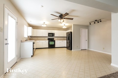 A spacious kitchen with white cabinets and appliances.