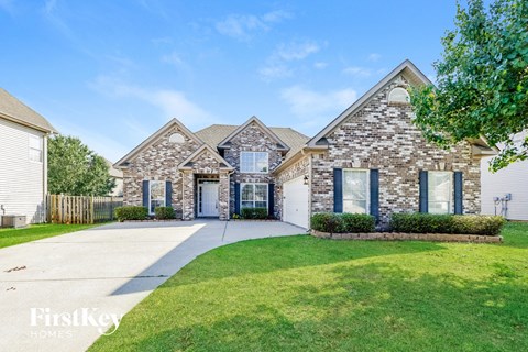 a large brick house with blue doors and a driveway