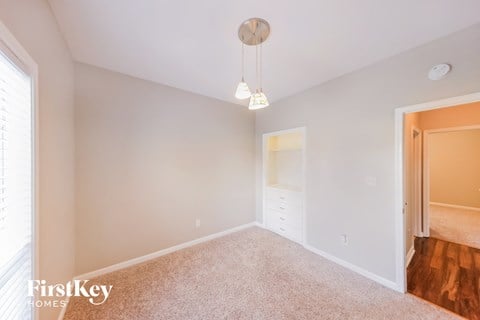 a bedroom with white carpet and a closet with a door