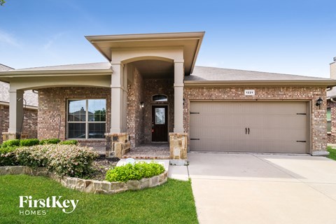 A house with a garage and a driveway in front of it.