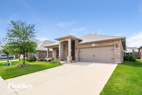 A house with a garage and a driveway in front of it.