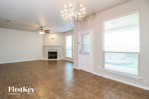 A spacious room with a fireplace and a chandelier.