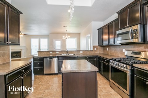 A kitchen with black cabinets and a stainless steel dishwasher.
