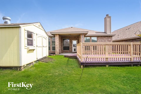 A house with a yellow exterior and a wooden deck.