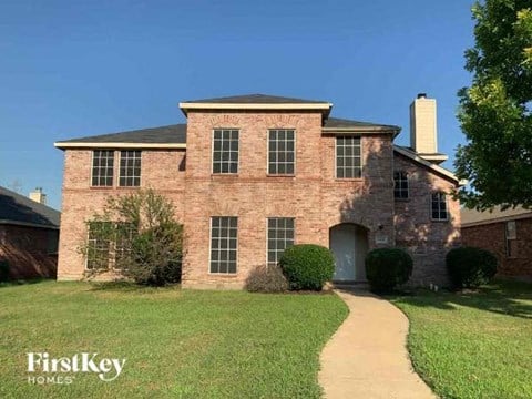 a brick house with a walkway in front of it