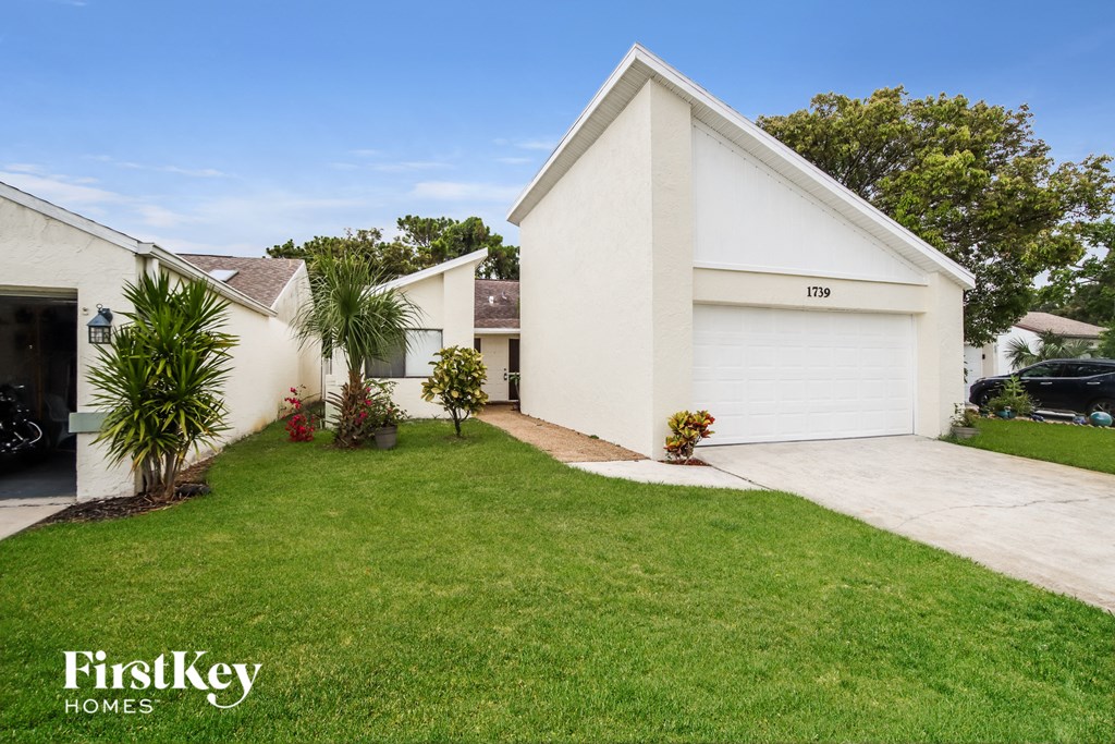 a white house with a lawn and a driveway