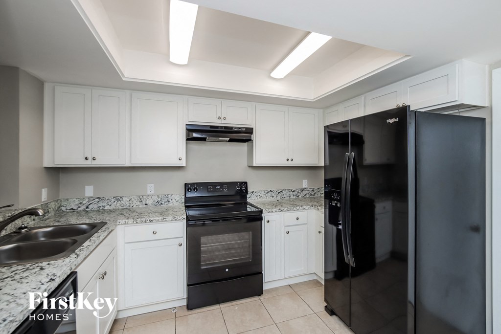 a kitchen with black appliances and white cabinets