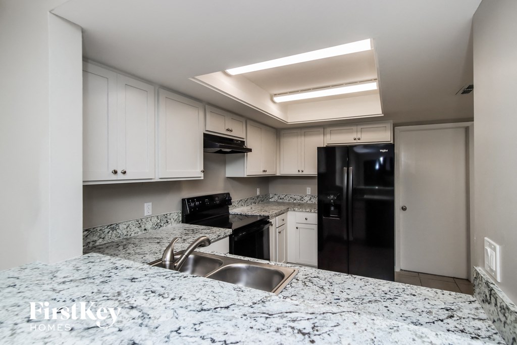 a kitchen with granite counter tops and black appliances