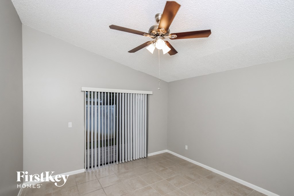 the living room has a radiator and a ceiling fan