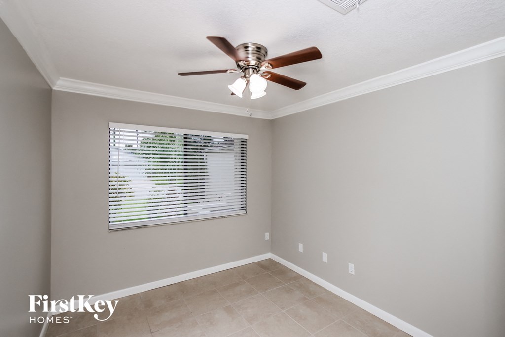 a bedroom with a ceiling fan and a window