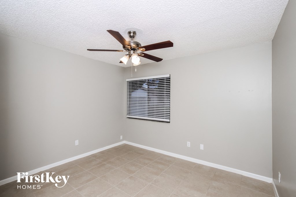 a living room with a ceiling fan and a tiled floor