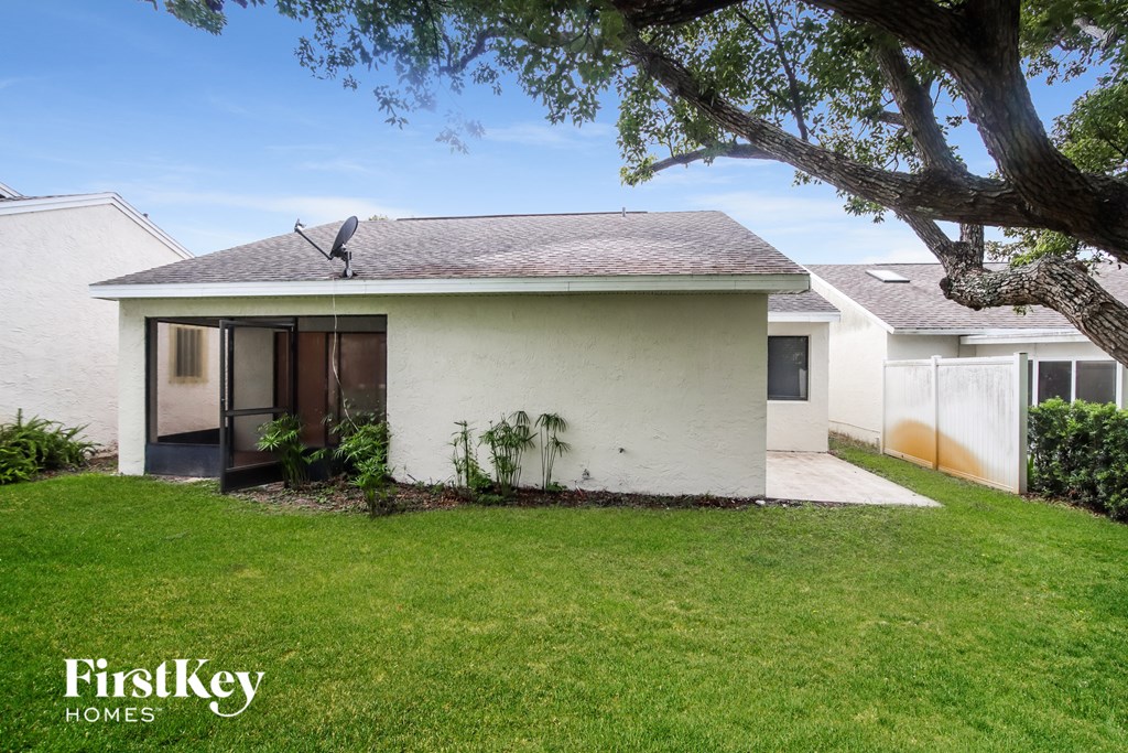 a white house with a yard and a tree