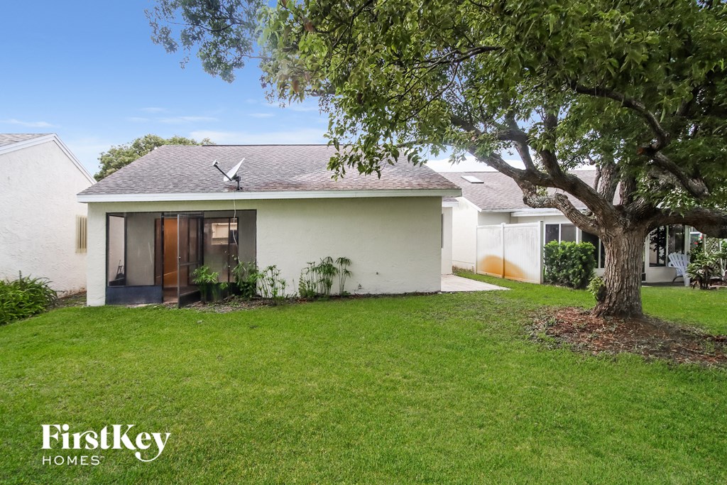 a white house with a yard and a tree