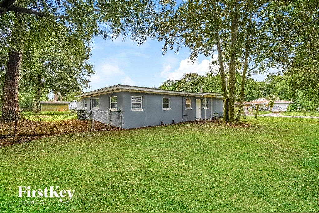 a blue house with a yard and trees