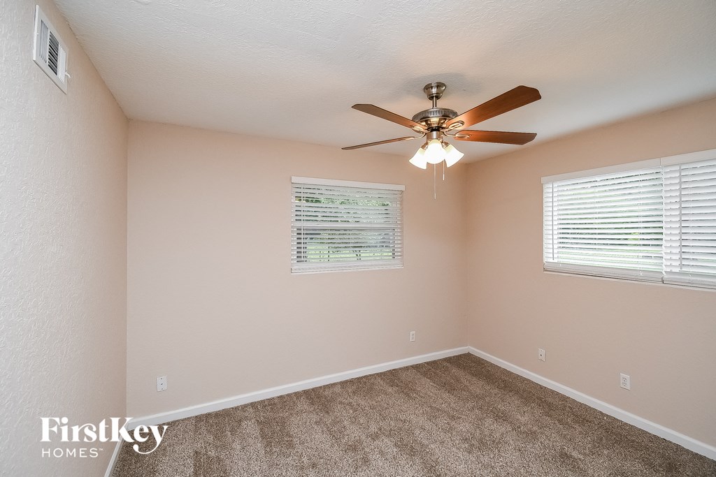 a bedroom with a ceiling fan and a window