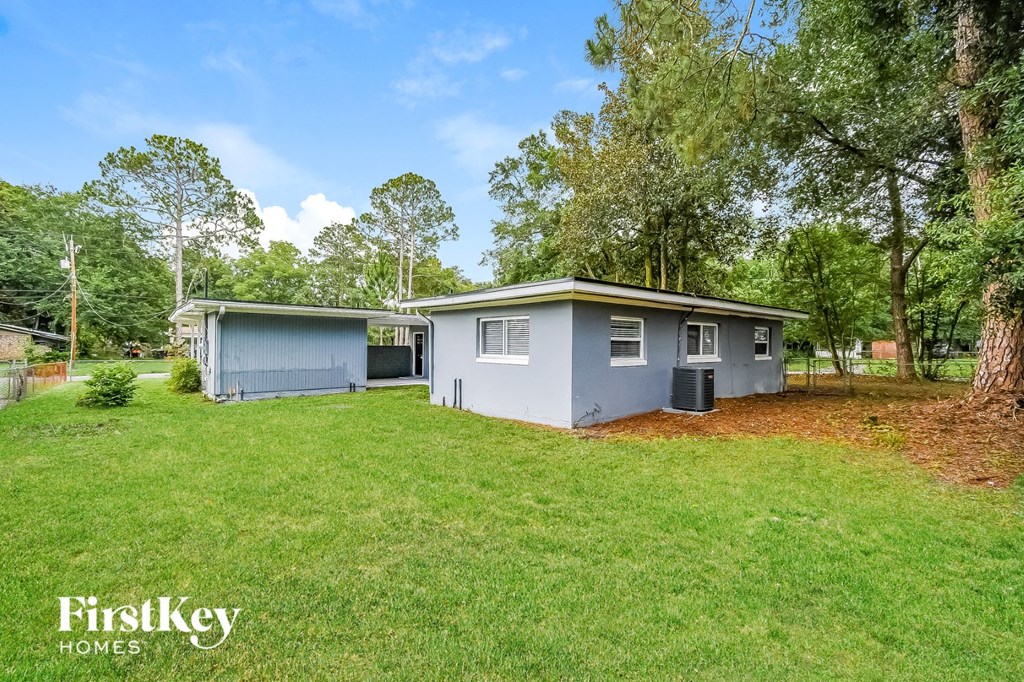 a blue house with a grassy yard and trees