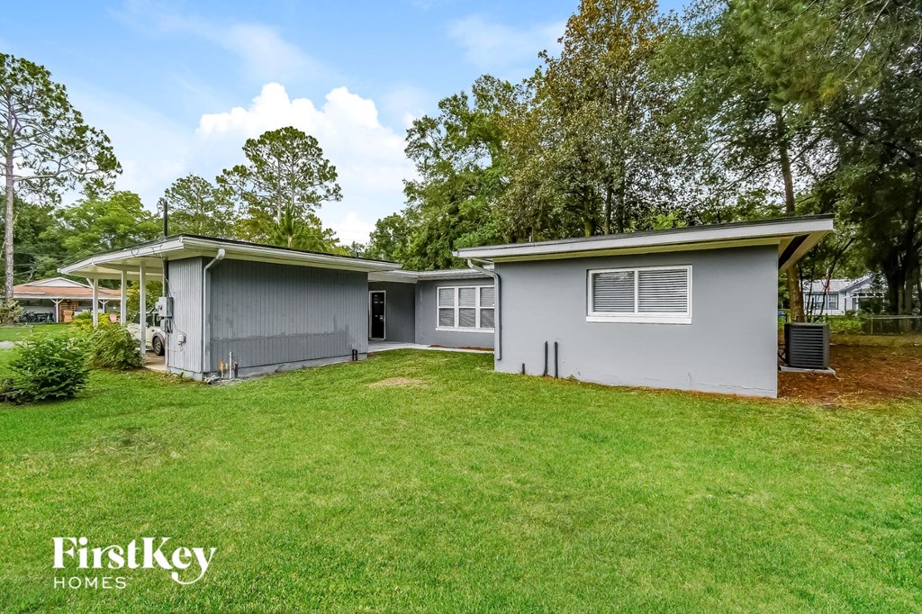 a gray house with a grassy yard and a garage
