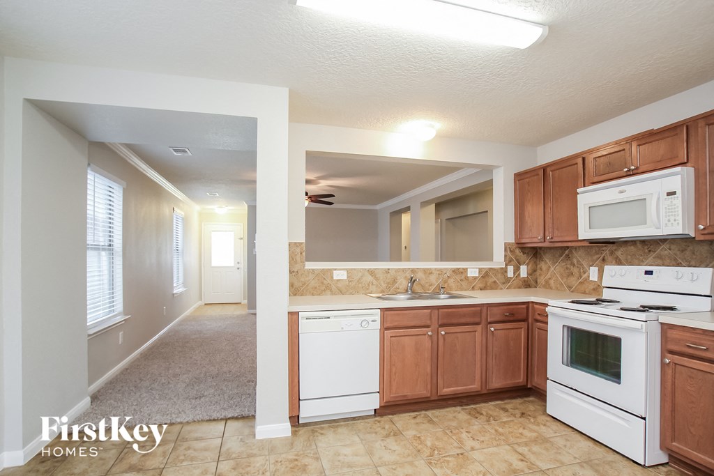 a kitchen with white appliances and wooden cabinets
