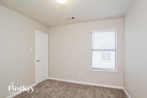 a bedroom with carpet and a window and a door