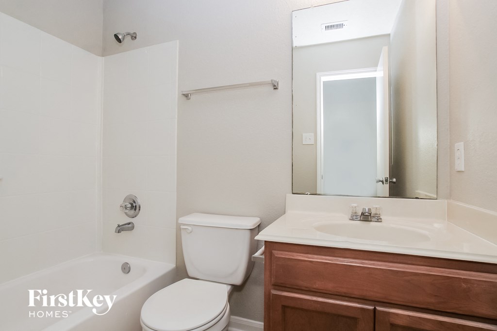 a bathroom with a toilet sink and mirror and a tub