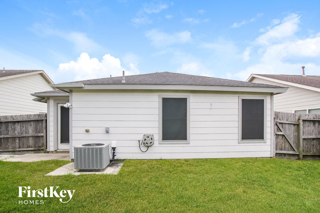 the backyard of a white house with a heater in the yard