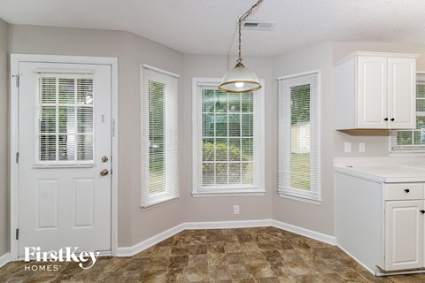 a kitchen with white cabinets and a sink and a window